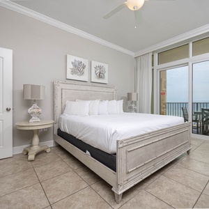 Relax in the serene master bedroom featuring a king bed, stylish decor, and beachfront balcony access