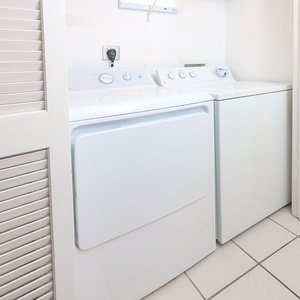 The laundry area features a stacked washer and dryer in a clean, white space, ensuring convenience during your stay