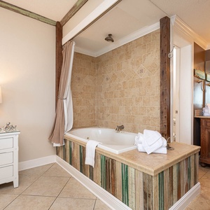 Indulge in relaxation with a spacious jetted tub, stylish decor, and view to the master suite and beachfront balcony