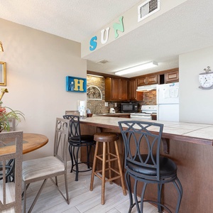 This inviting kitchen features rich wood cabinetry, a breakfast bar, and a cozy dining area perfect for meals together