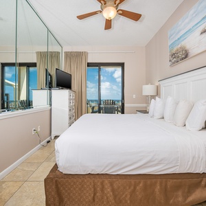 Unwind in the serene master bedroom featuring a king bed, a TV, and direct access to the balcony with beautiful views