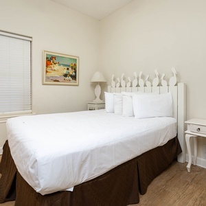 Rest in this serene guest bedroom featuring a comfortablequeen  bed, charming decor, and natural light from the window
