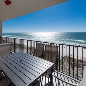 Savor meals at the outdoor table while enjoying the expansive views of the shimmering water and beach below