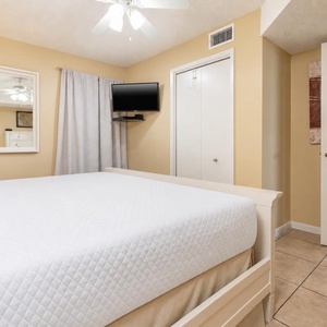 Relax in the bedroom featuring a cozy bed, a TV, and soft lighting for a restful stay