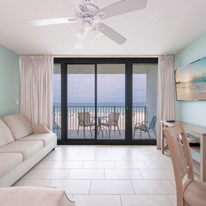 Unwind in the living area, featuring a TV and easy access to the balcony with views of the tranquil waters
