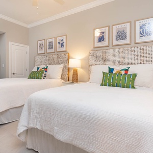 Relax on one of the cozy queen beds in this guest suite with charming decor and enjoy a peaceful rest