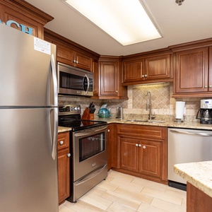 Rich wooden cabinetry complements the kitchen's stainless appliances and granite countertops, creating a welcoming space