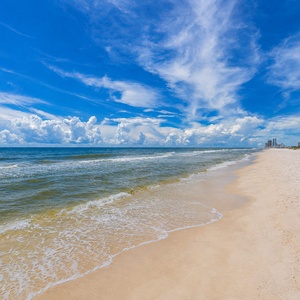 Bask in the stunning beachfront view with sparkling waves and a glistening sun, perfect for your beach getaway