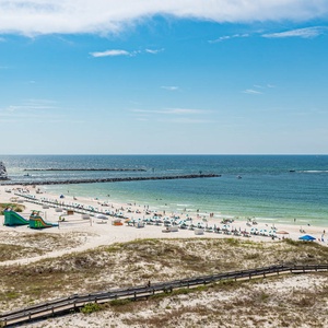 Take in the stunning beach view with vibrant umbrellas and gentle waves, perfect for a relaxing getaway