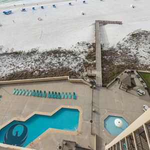Experience a breathtaking view of the beach and pool area from this stunning balcony, perfect for relaxation and sunbathing