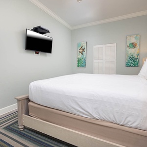 Unwind in the tranquil guest bedroom featuring a plush king bed, colorful art, and a cozy area rug