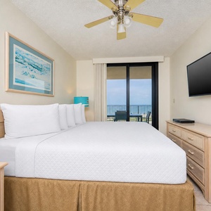 Unwind in the master bedroom featuring a king bed and direct access to a balcony with inviting views