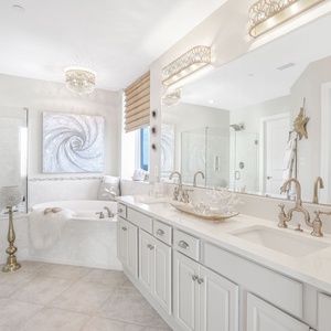 The master bathroom features elegant fixtures, a luxurious soaking tub, and a serene view through the window