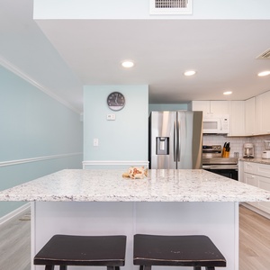 Gather around the sleek counter and enjoy family chats while planning your beachside adventures in the inviting kitchen