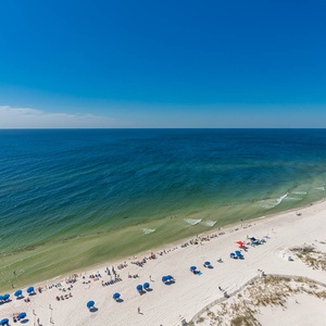 This stunning beachfront view showcases inviting sandy shores and vibrant blue umbrellas, perfect for a relaxing getaway