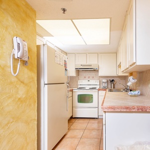 Kitchen featuring white appliances, warm-toned countertops, and a cozy atmosphere perfect for meal preparation
