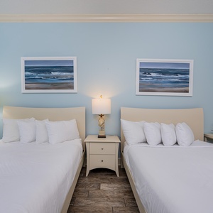 Drift into restful nights on the fluffy queen beds in this guest bedroom that invites relaxation