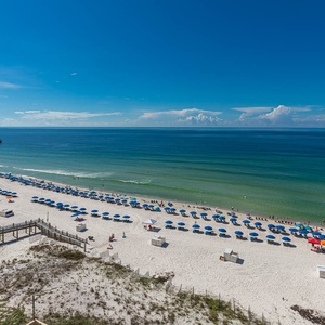 Stunning view of a pristine beach with colorful umbrellas and clear blue water under a bright sky