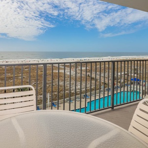 Balcony seating offers a serene view of the beach and the inviting pool area, perfect for relaxation and enjoyment