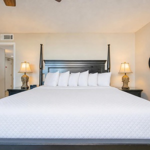 Rest in the king master suite, surrounded by calming decor and warm light, perfect for restful nights after beach days