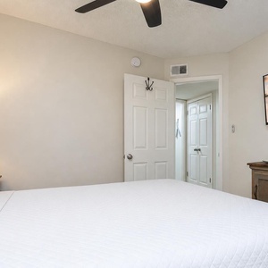 Master bedroom featuring a large king bed, a mounted TV, and warm lighting for a relaxing retreat