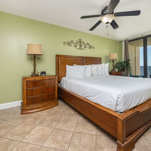 Relax in this master bedroom featuring a plush king bed, elegant furnishings, and a balcony with a beautiful view