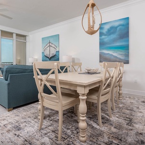 Gather at the dining table under coastal art and watch the gulf sparkle beyond the glass doors