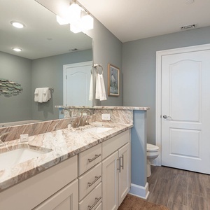 Refresh in the master bath after a day at the beach with a soothing tub and relaxing walk-in shower