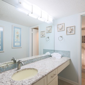 Brighten your day in this master bath featuring a spacious vanity, decorative art, and a refreshing walk-in shower