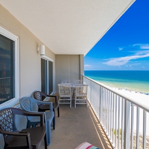 Relax with breathtaking beachfront views from this balcony, featuring comfortable seating and a dining area