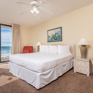 Relax in this master bedroom with a king bed, cozy seating, and sliding doors that open to breathtaking beach views