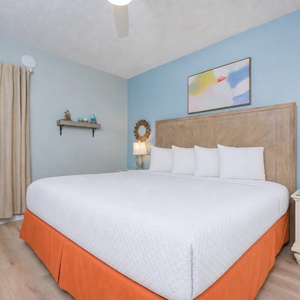 Plush white linens invite you to sink into the king suite's bed while the TV plays your favorite show nearby
