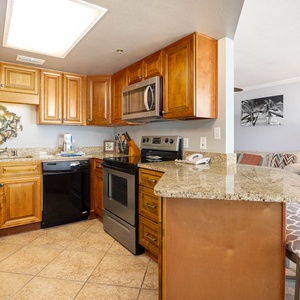 Kitchen featuring wooden cabinetry, a granite countertop, and a breakfast bar with stylish seating