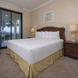Retreat to the king master suite with cozy bedding and drift off to the sound of the waves from the patio
