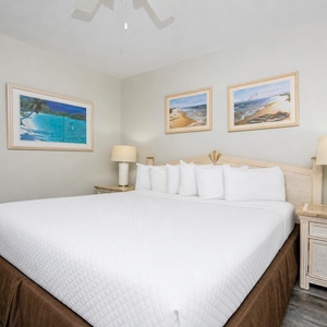 Rest comfortably in this inviting bedroom, featuring a spacious king bed and beach-themed artwork that enhances relaxation
