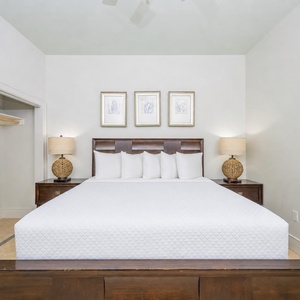 This guest bedroom features a large bed with plush pillows, stylish lamps, and framed artwork, creating a serene retreat