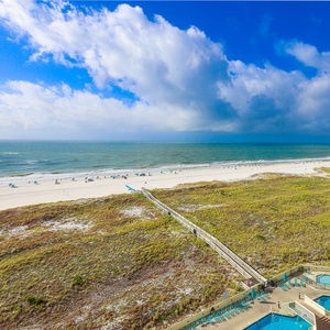 Beach view showcases the inviting beach, with gentle waves lapping against the shore and sunbathers enjoying the sun