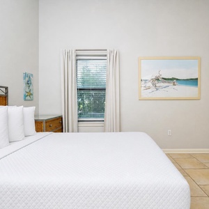 Rest in this guest bedroom featuring a queen bed, stylish decor, and natural light streaming through the window