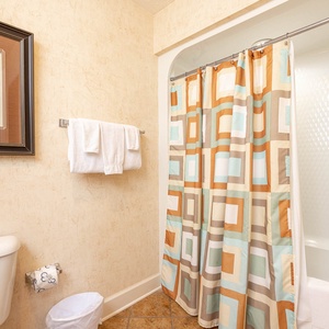 Enjoy refreshing morning showers in this guest bath, surrounded by soft towels and calming beach decor