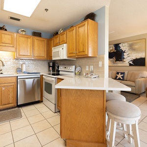 Brew your morning coffee at the breakfast bar as warm light fills the cozy kitchen space