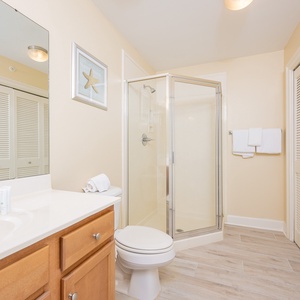 Additional bath featuring a walk-in shower, modern fixtures, laundry area with washer/dryer, and warm wooden cabinetry