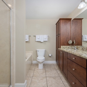 Experience a relaxing retreat in the master bathroom, featuring a stylish vanity, a walk-in shower, and a jetted tub