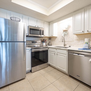 This kitchen features stainless appliances, white cabinetry, and a coffee maker, perfect for preparing meals during your stay