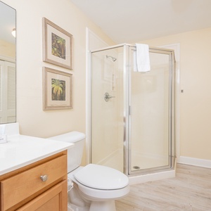 Additional bath featuring a walk-in shower, stylish decor, laundry area with washer/dryer, and warm wood accents