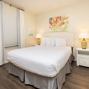 Relax in this serene guest bedroom featuring a queen bed, charming decor, and soft lighting for a restful stay