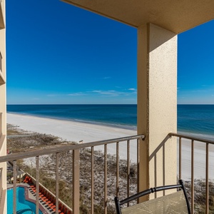 The balcony offers a breathtaking view of the tranquil beach and clear blue waters, perfect for relaxation and enjoyment