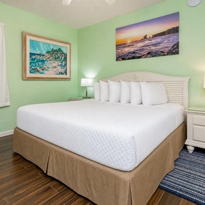 Soft lamps glow beside the bed in the king suite where you rest after a day along the coast