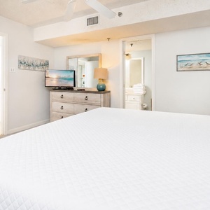 Crisp white linens cover your king bed where you unwind watching your favorite shows on TV