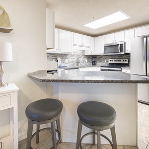 Gather at the sleek bar stools for a casual meal or drink while enjoying the inviting kitchen atmosphere