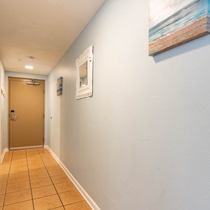 Step into a welcoming hallway adorned with beach-themed decor, leading you to your vacation retreat